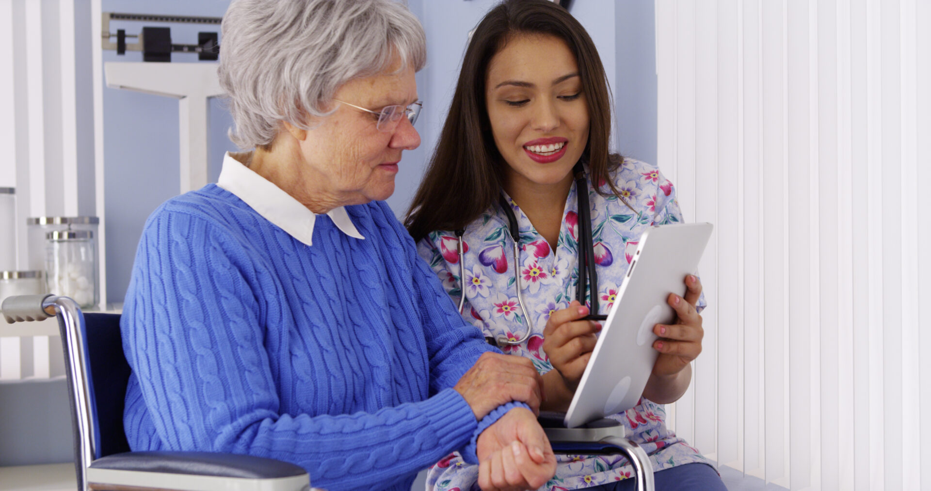 A woman and an older person looking at a tablet.